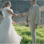 Bride and groom dancing in sunlit meadow near ancient ruins during Cyprus wedding