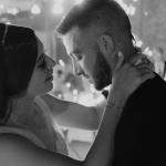 Bride and groom in emotional first dance with indoor fireworks and guests in background