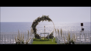 Floral arch at Kerry and Stephen's wedding ceremony with the sea in the background