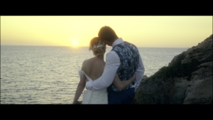 Kerry and Stephen embracing while watching the sunset over the sea